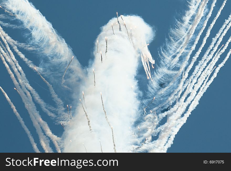 This abstract bird is photographed during celebratory aviashow. Day fireworks against the blue sky. This abstract bird is photographed during celebratory aviashow. Day fireworks against the blue sky.