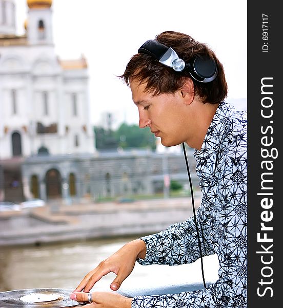 DJ Roman Kravtsov with his headphones playing outside. DJ Roman Kravtsov with his headphones playing outside