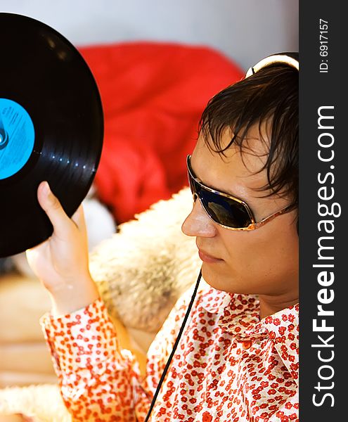 DJ with his headphones on the street holding vinyl disc. DJ with his headphones on the street holding vinyl disc