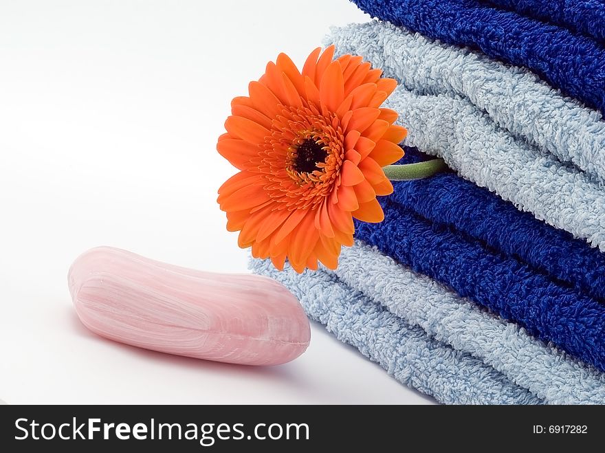 Blue towels, soap and flower on the white background