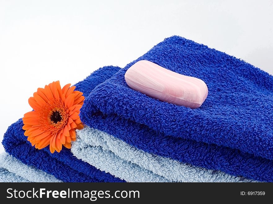 Blue towels, soap and flower