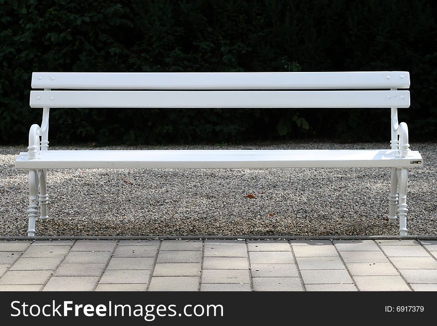 A light green bench in front of a dark background. A light green bench in front of a dark background