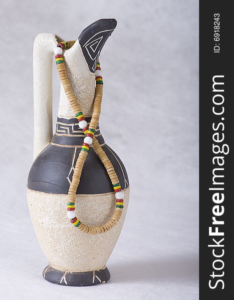 Old-fashioned clay jug with greek ornament and beads. Old-fashioned clay jug with greek ornament and beads
