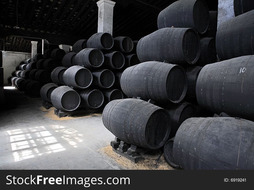 Old wooden barrels of sherry in bodega of Spanish town of Jerez de la Frontera