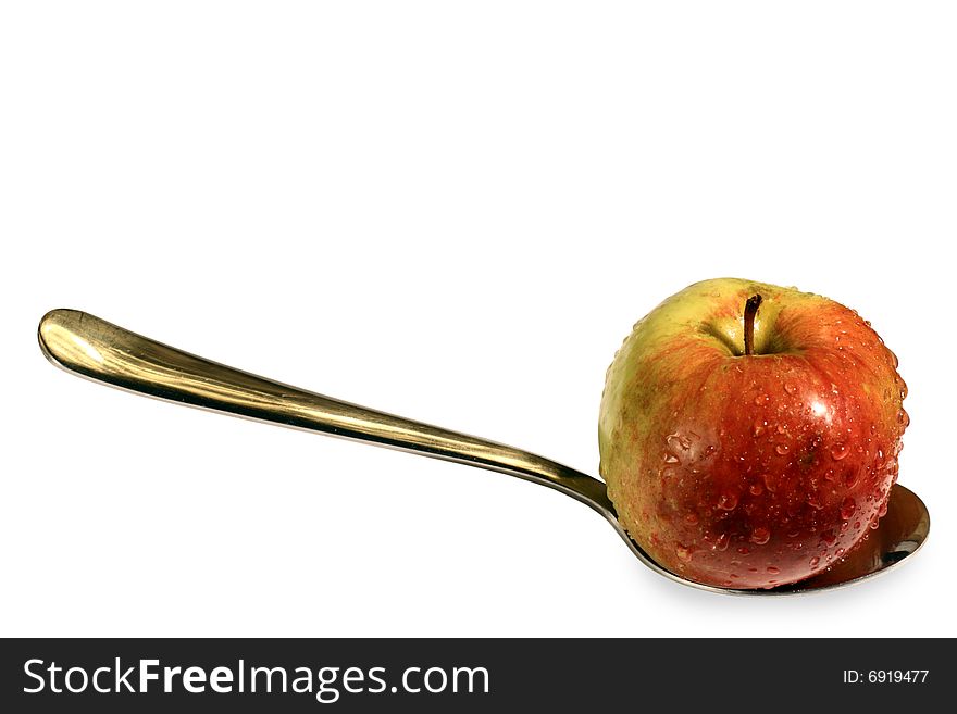 A healthy apple on a spoon. Water drops suggest freshness. A healthy apple on a spoon. Water drops suggest freshness.