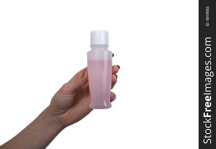 The female hand holds on an open palm a small bottle with perfumery on a white background. The female hand holds on an open palm a small bottle with perfumery on a white background