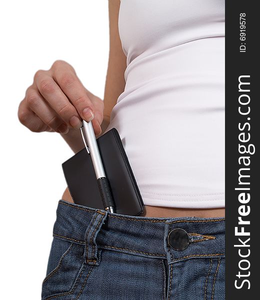 The female hand fills the pocket with a notebook of jeans. The female hand fills the pocket with a notebook of jeans