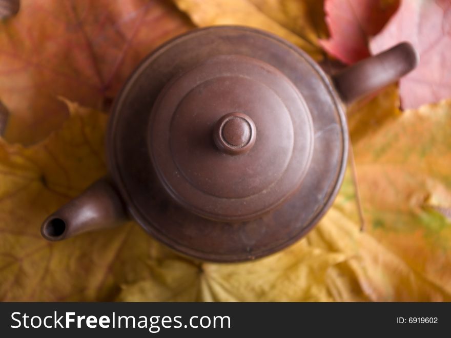 Tea pot on the yellow and red leafs. Tea pot on the yellow and red leafs.