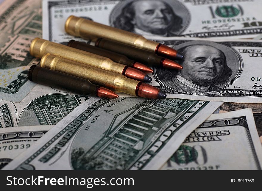 Bullets lying on dollar banknotes. Bullets lying on dollar banknotes