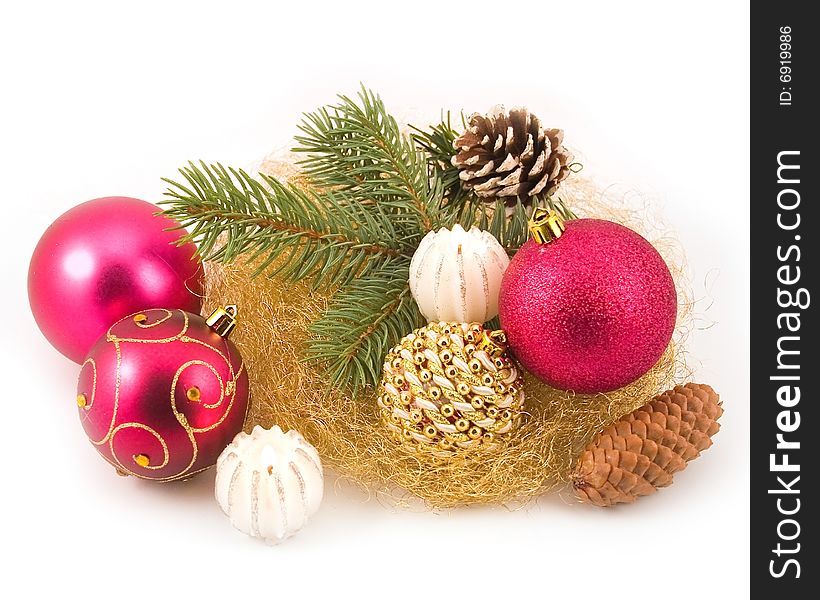 Gold tinsel with New Year's spheres and branches of fur-trees on white background