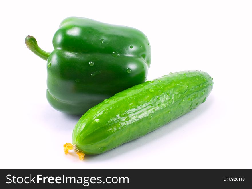 Green bell pepper and cucumber isolated over white