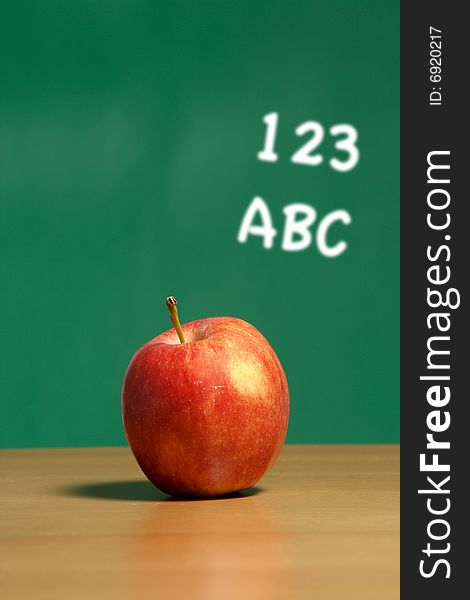 An apple on a desk in a classroom
