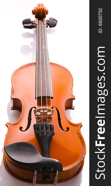 An old student level violin on a reflective white background. An old student level violin on a reflective white background