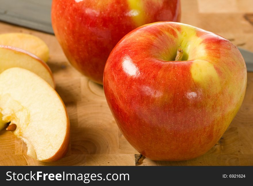 Fresh cut ambrosia apples on a wood block cutting board. Fresh cut ambrosia apples on a wood block cutting board