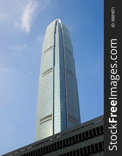 Hongkong Central with highest skyscraper, blue sky as background with passanger's plane far in distance. Hongkong Central with highest skyscraper, blue sky as background with passanger's plane far in distance.