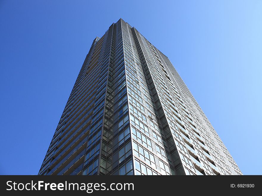 Glass and concrete tower against a blue sky. Glass and concrete tower against a blue sky