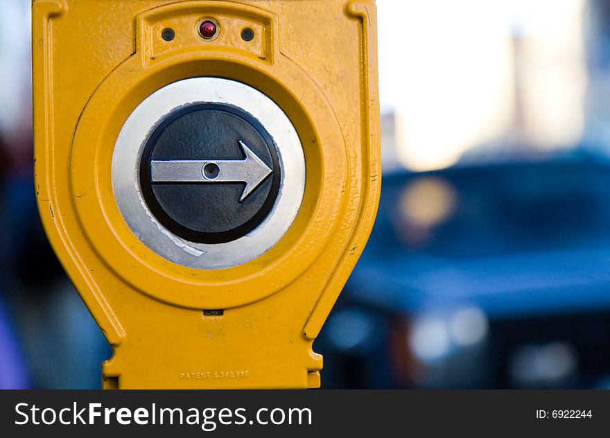 Crosswalk button pointing to the right surrounded by a yellow casing. Crosswalk button pointing to the right surrounded by a yellow casing