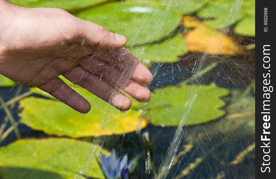 Hand and splashes of water in fountain