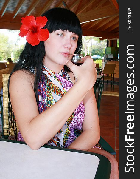 Girl the brunette with a flower and glass. Girl the brunette with a flower and glass