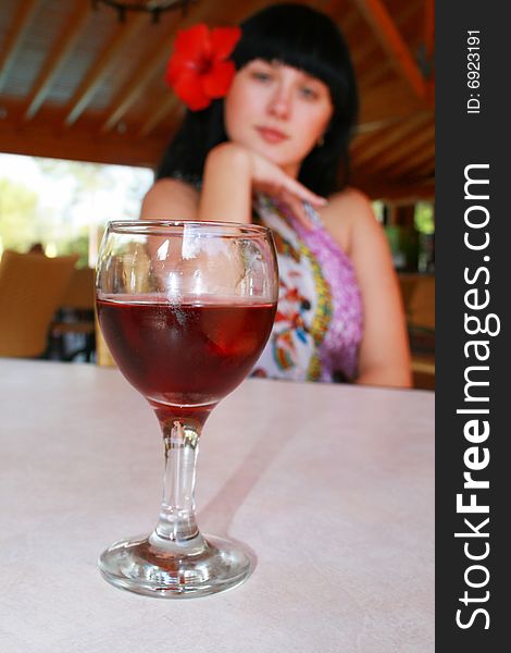 Girl the brunette with a flower and glass. Girl the brunette with a flower and glass