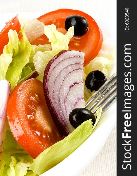 Fresh salad with lettuce, tomato, onion and olive