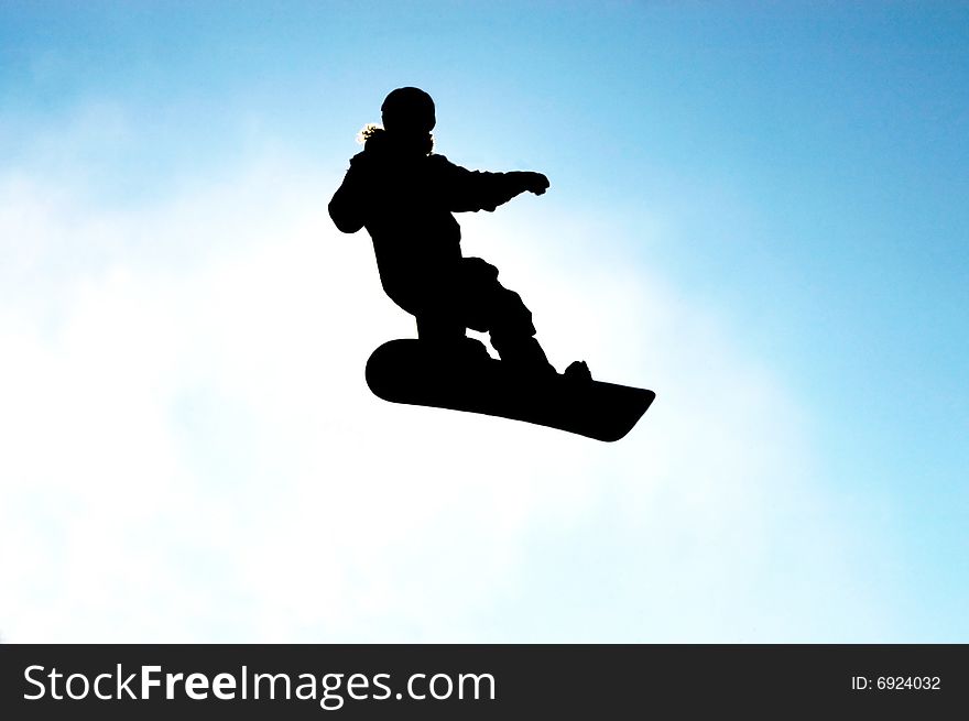 A snowboarder in action against blue sky