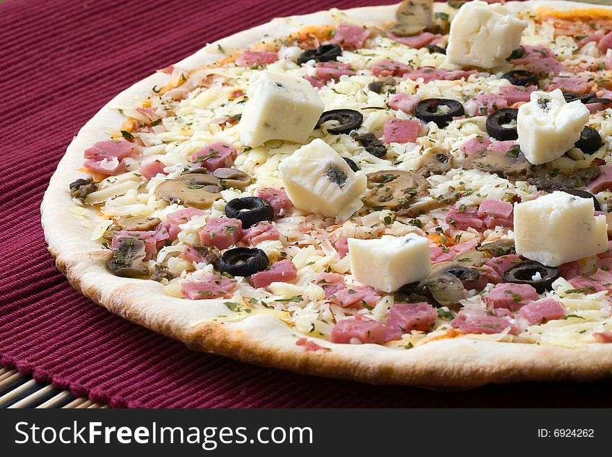 Tasty gorgonzola cheese pizza with black olives on red background