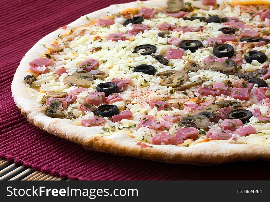 Tasty romana style pizza with black olives on red background