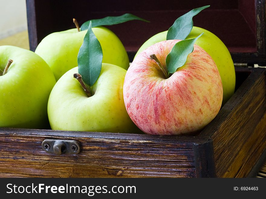 A wooden box with green and red apple. A wooden box with green and red apple