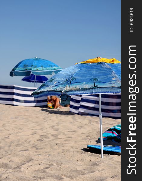 Blue umbrellas and veils on sandy beach. Blue umbrellas and veils on sandy beach