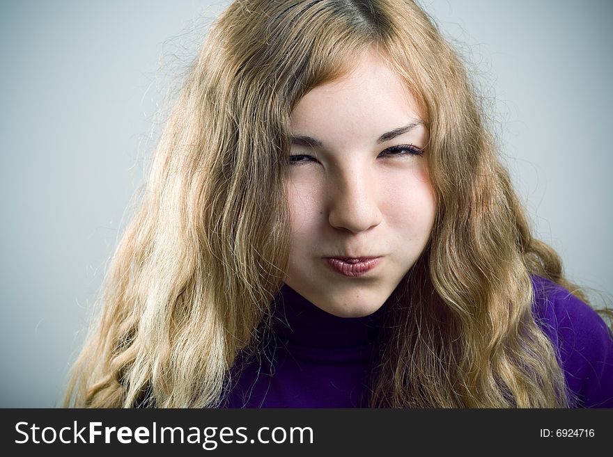 Young beautiful girl blowing cheeks.