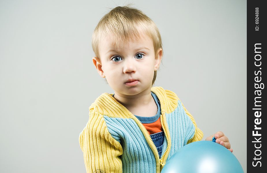 Little boy with blue balloon looking at camera. Little boy with blue balloon looking at camera.