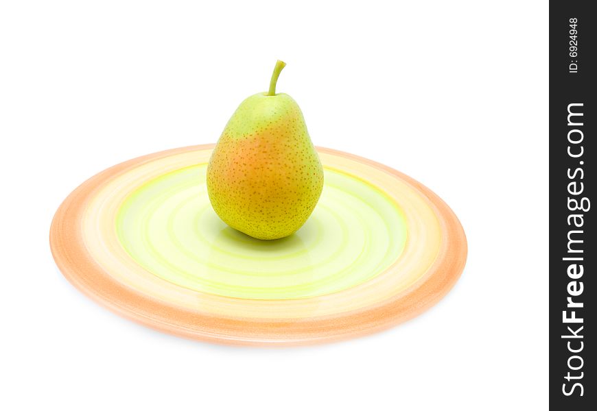 Green pear on a plate over white.
