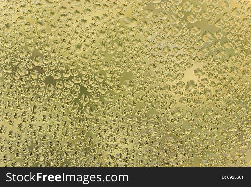 Abstract yellow background (raindrops on yellow glass)