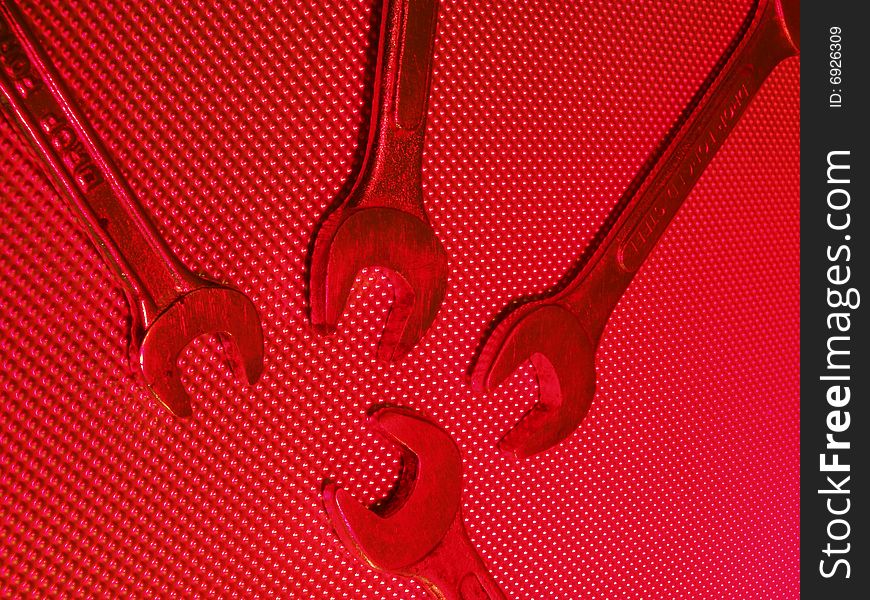 Spanners shot in red light on metal plated background. Spanners shot in red light on metal plated background