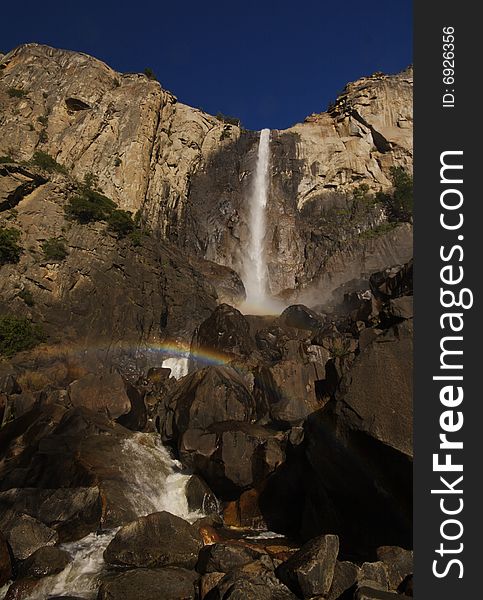Waterfall in yosemite valley with rainbow in foreground. Waterfall in yosemite valley with rainbow in foreground
