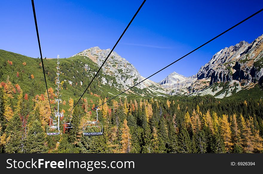 Chairlift climbing on fall mountains. Chairlift climbing on fall mountains