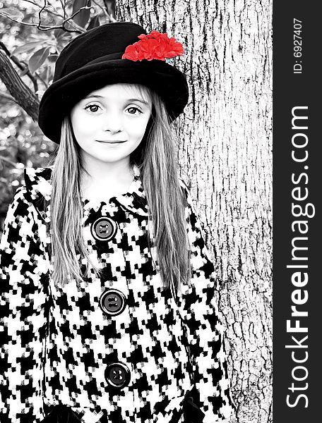 Little girl wearing a coat and a hat with a red flower. Little girl wearing a coat and a hat with a red flower