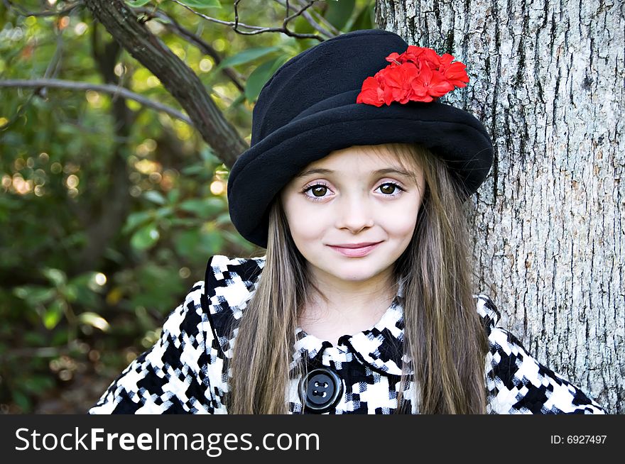 Close-up of little girl wearing a hat in an outdoor setting. Close-up of little girl wearing a hat in an outdoor setting.