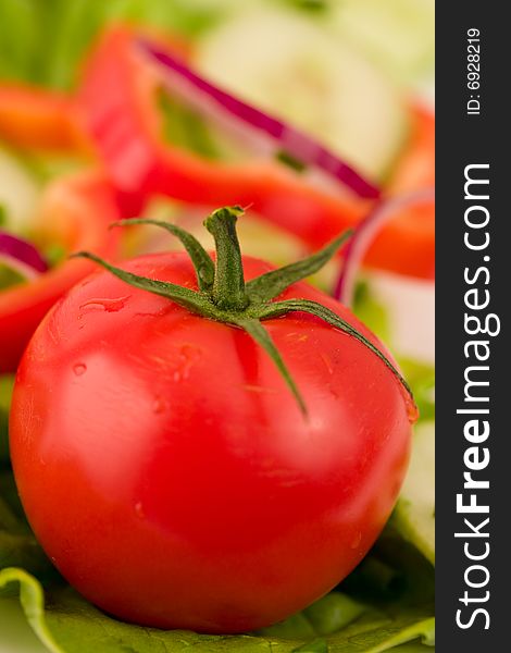 Closeup of a tomato on a bed of salad