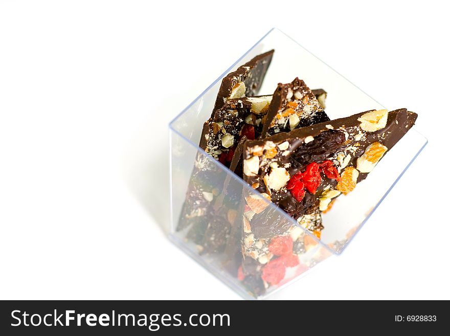 Glass bowl full of chocolate slices isolated on white background