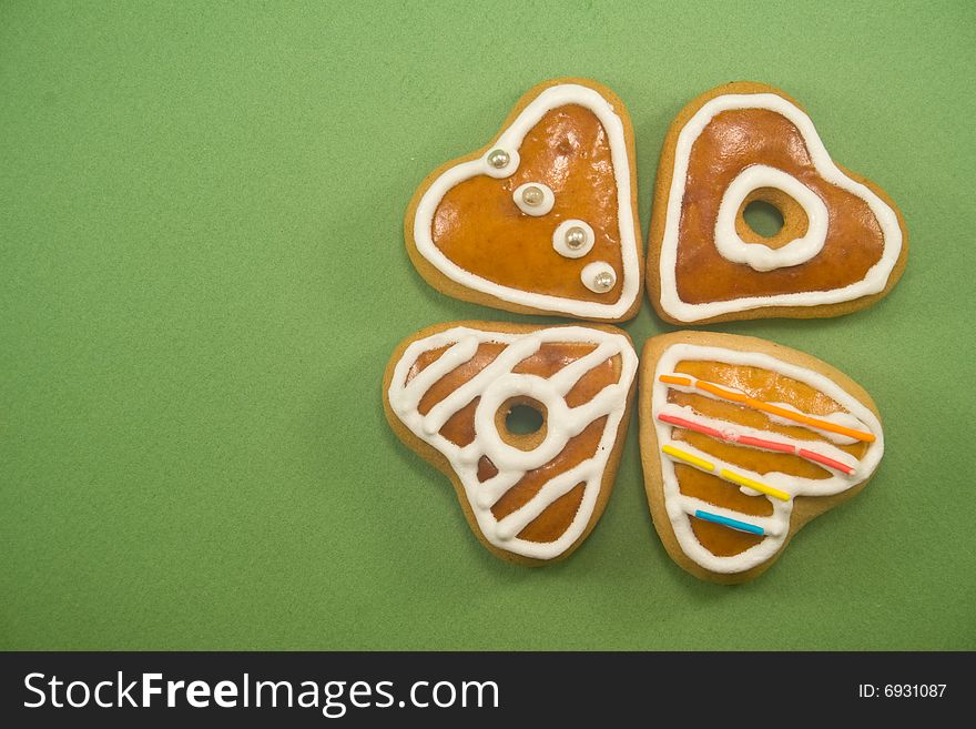 Decorated Christmas cookies in clover formation against green background ad space on left. Decorated Christmas cookies in clover formation against green background ad space on left