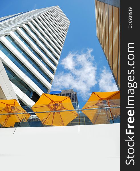 Modern building on a background of blue sky and yellow umbrella