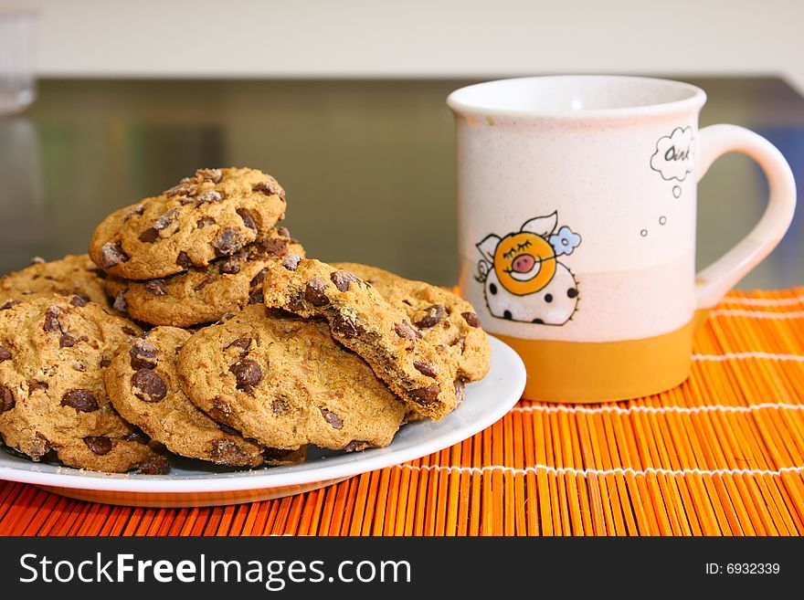 A few cookies on the plate and mug with cofee. A few cookies on the plate and mug with cofee