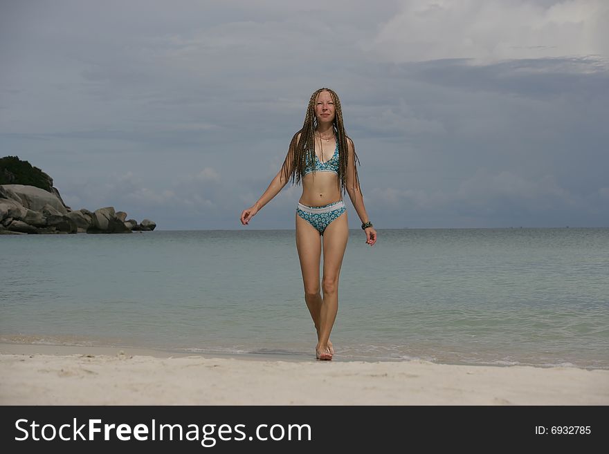 Young girl walking on the coast of the ocean. Young girl walking on the coast of the ocean