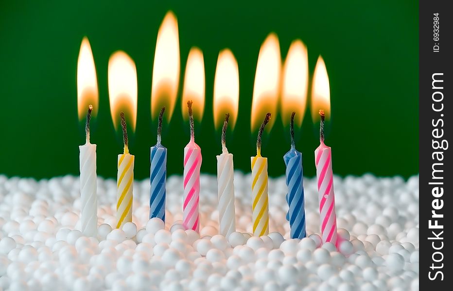 Beautiful colored candles over a green background. Beautiful colored candles over a green background