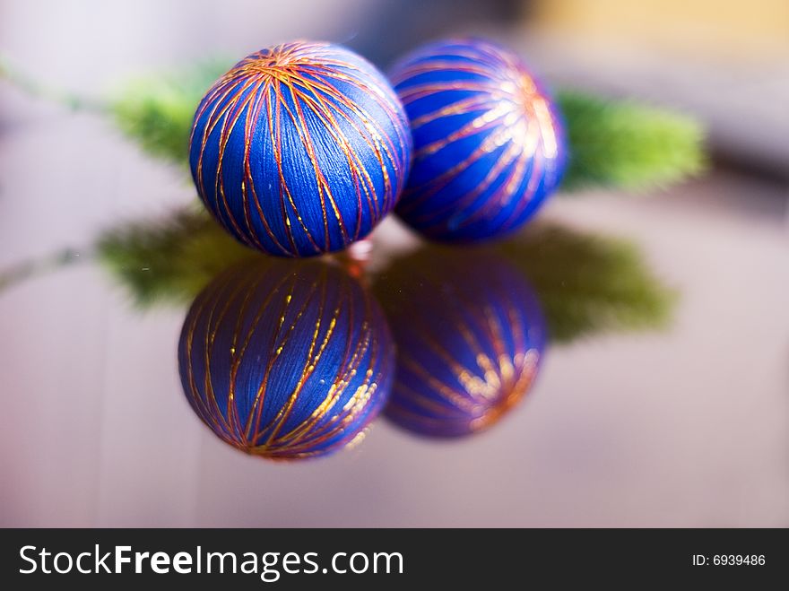 Two blue christmas balls with their reflection