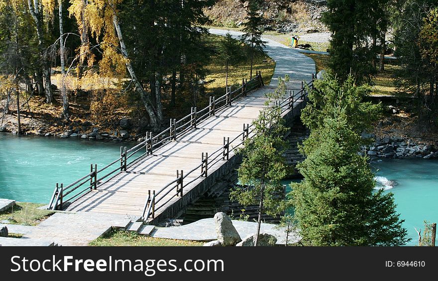 A wood bridge across Kanas river in the north of Xinjiang Province, China. A wood bridge across Kanas river in the north of Xinjiang Province, China.