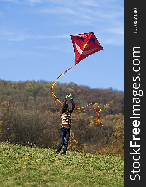 Fly a kite, teenager in fall weather in nature