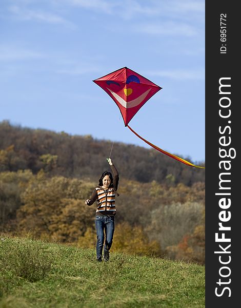 Fly a kite, teenager in fall weather in nature